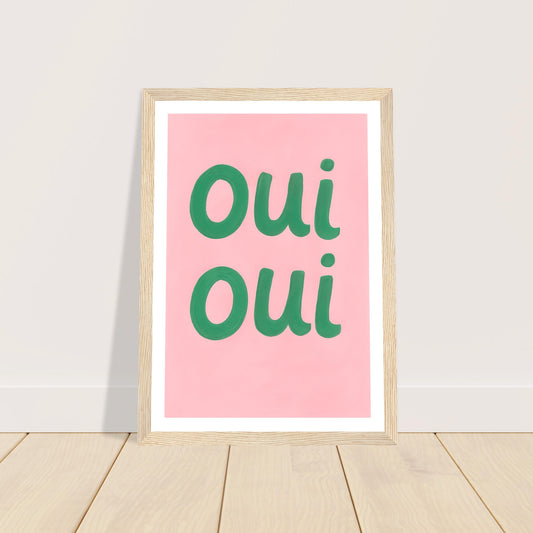 Green Oui Oui lettering on pink art print in a light wood frame, A4