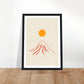 Orange sun over red mountain art print in a black wood frame, A4